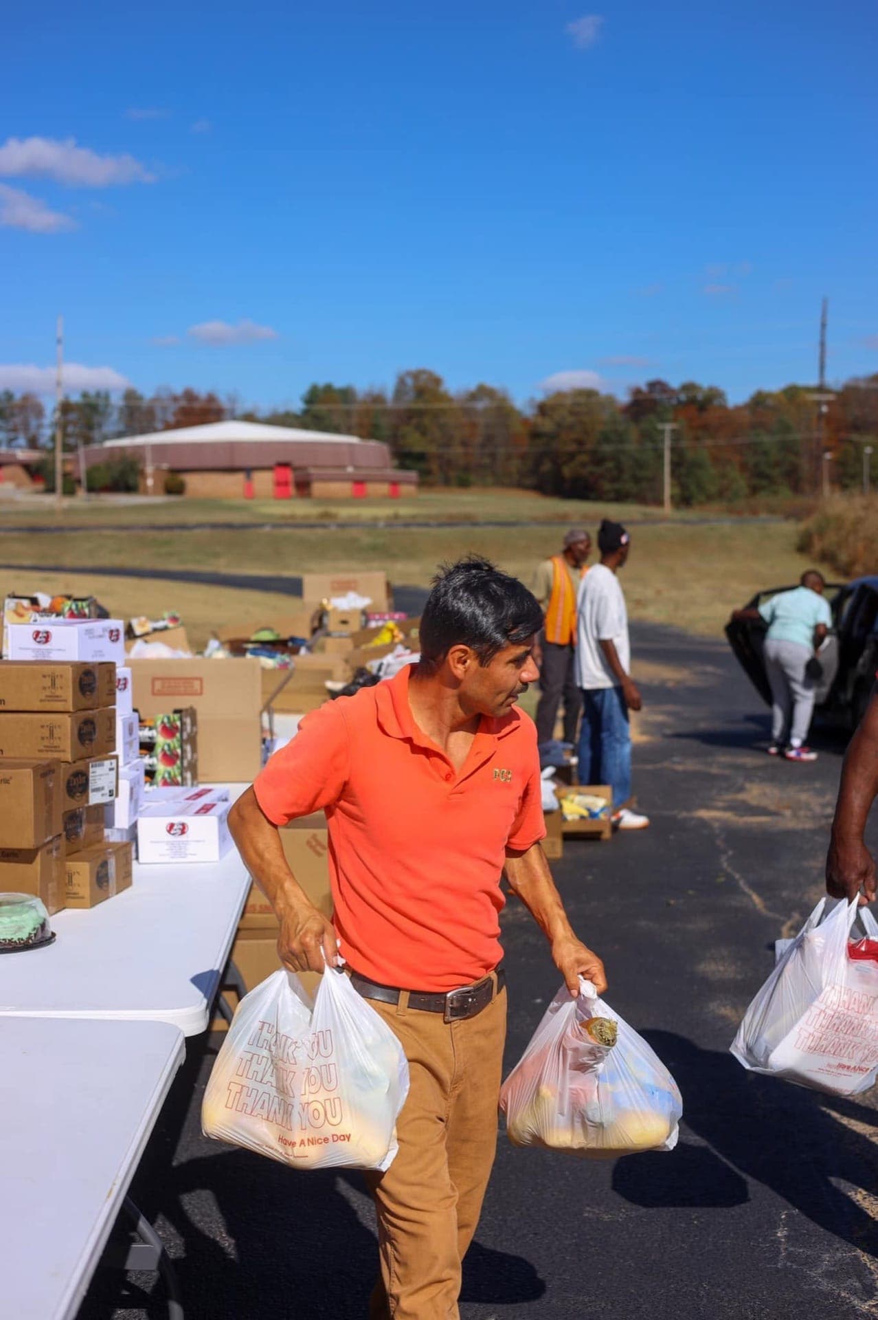An All Nations volunteer carrying bags of food to serve local families