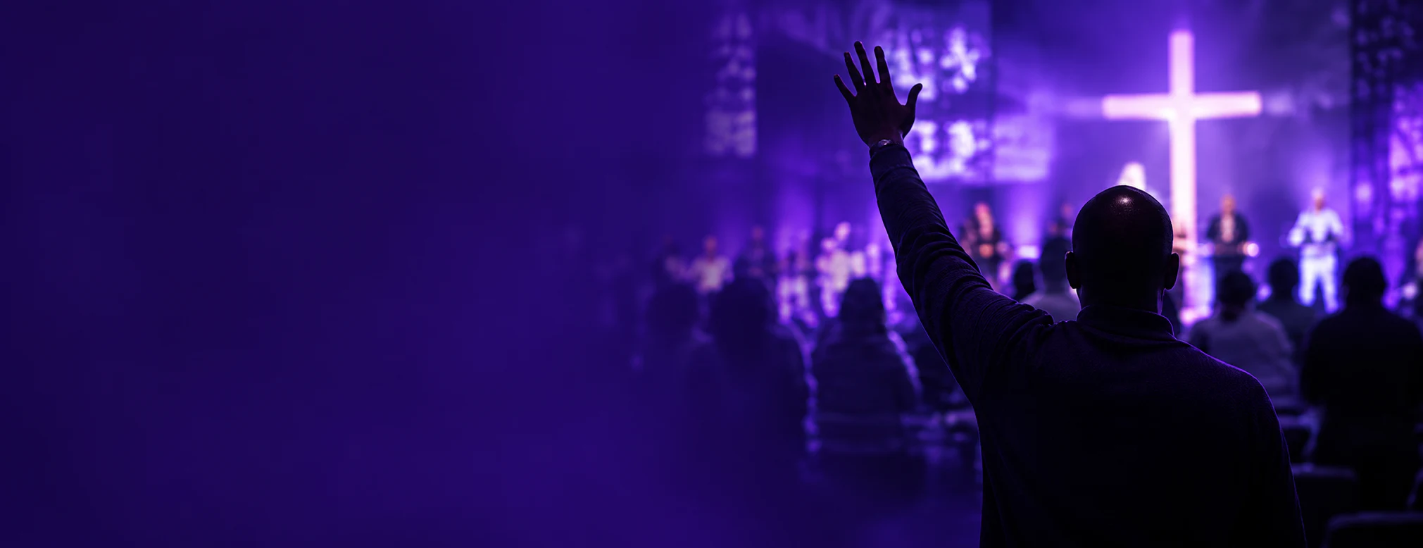 A worshipper raising a hand in a welcoming church gathering